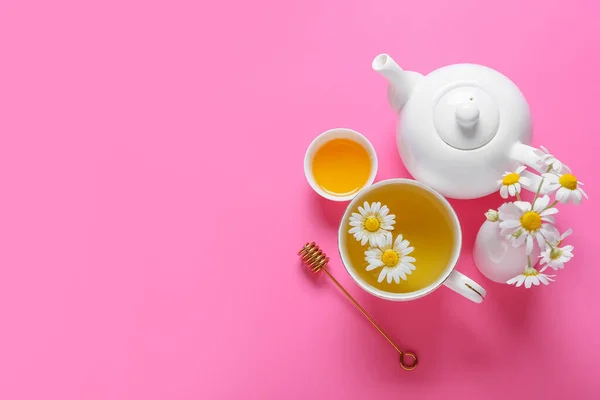 ティーポットとカップのおいしいカモミールティーピンクの背景に蜂蜜 — ストック写真