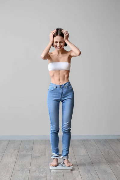 Mujer Estresada Con Anorexia Midiendo Peso Sobre Fondo Gris — Foto de Stock