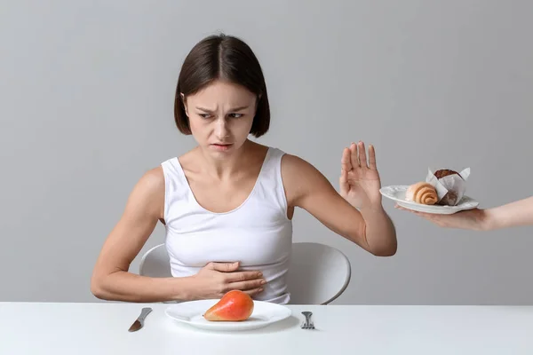 年轻女子拒绝吃灰色背景的食物 厌食症概念 — 图库照片