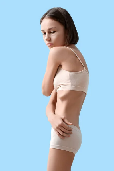 Young skinny woman on color background. Anorexia concept