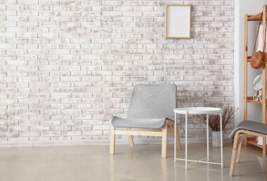 Koltuk şık tuğla duvarın yanında.