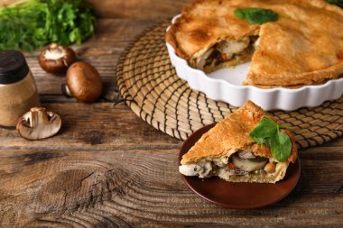 Ahşap arka planda lezzetli tavuklu turta tabağı.