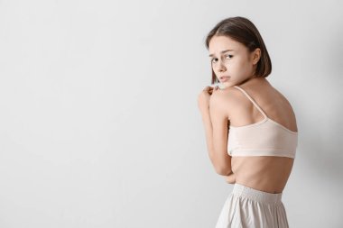 Hafif arka planda genç, zayıf bir kadın. Anoreksi kavramı