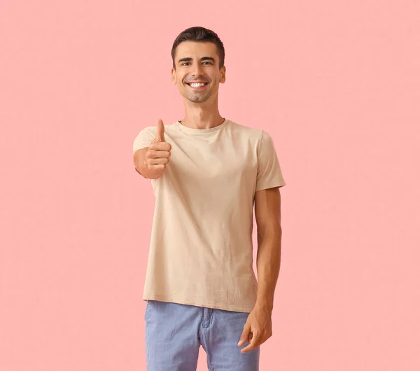 ハンサムな若いです男でスタイリッシュなTシャツショー親指アップ上の色の背景 — ストック写真