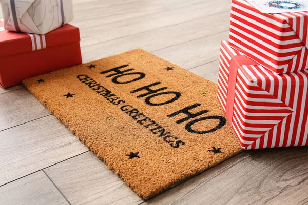 Door mat with Christmas gifts on floor