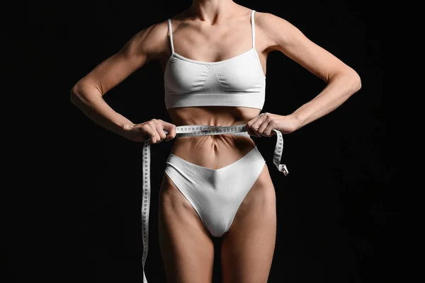 暗い背景にテープを測定している若い女性 拒食症の概念 — ストック写真