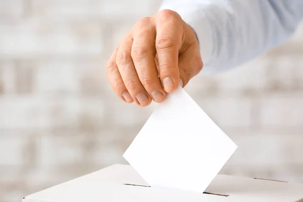 Głosujący Człowiek Pobliżu Urny Wyborczej Jasnym Tle — Zdjęcie stockowe