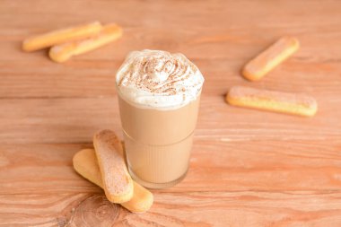 Ahşap arka planda bir bardak lezzetli Tiramisu Latte.