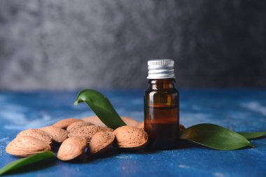 Koyu arkaplanda bir şişe badem yağı.