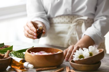 Kadın tabakta suya gerekli yağı ekliyor.