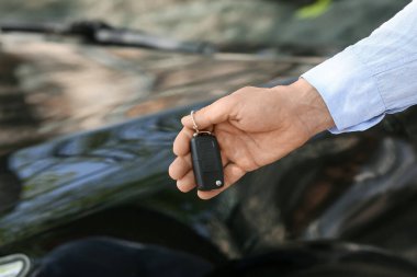 Dışarıda arabanın yanında anahtarı olan adam, yakın plan.