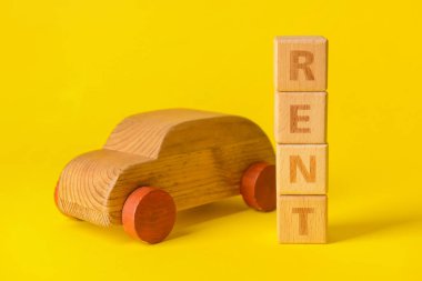 Tahta bir araba ve sarı arka planda kelime kırbacı.