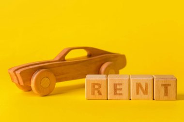 Tahta bir araba ve sarı arka planda kelime kırbacı.