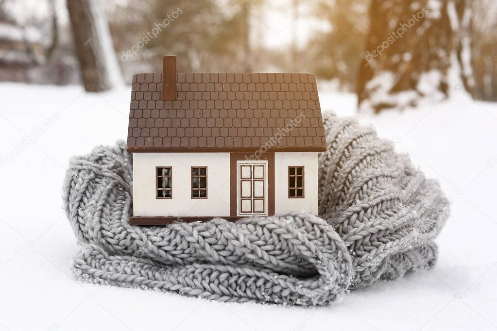 Figure of house and scarf on winter day. Concept of heating season