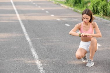 Sportif bayan koşucu nabzını kontrol ediyor.