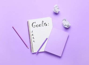 Liste yapmak için boş olan defter ve renk arkaplanı için kırtasiye malzemesi. Yeni yıl hedefleri