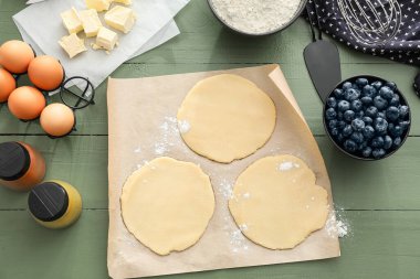 Yaban mersini galetleri için malzemeli ham hamur renkli ahşap arka plan
