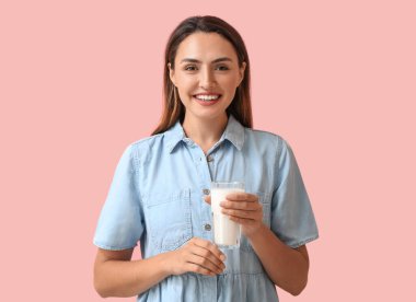 Arka planda bir bardak taze sütle genç bir kadın.