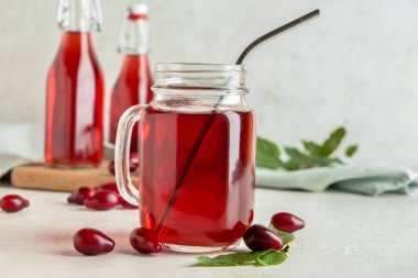 Mason kavanozu hafif arka planda sağlıklı kızılcık meyvesi içeceği.