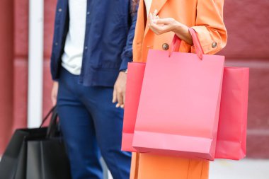 Şehir caddesinde alışveriş torbalı bir çift.
