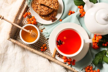 Hafif kumaş arka planda bir fincan lezzetli rowan çayı, yakın plan.