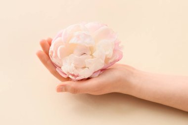 Hafif arka planda çiçekli bir kadın eli