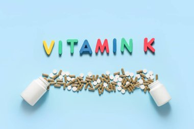 Kelime VITAMIN K ile kompozisyon ve renk arkaplan üzerinde haplar