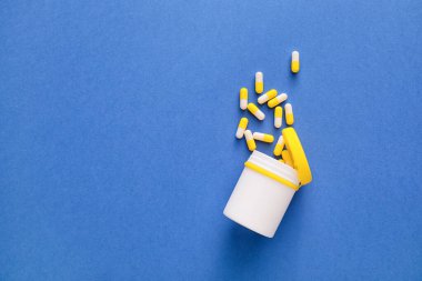 kapsül üzerinde mavi arka plan ile şişe