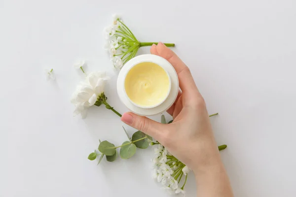 Vrouwelijke Hand Met Pot Cosmetisch Product Bloemen Witte Achtergrond — Stockfoto