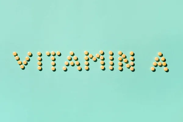 Metin Vitamin Renk Arkaplanındaki Sarı Haplardan Yapılmış — Stok fotoğraf