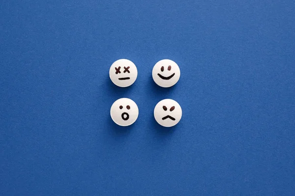 Таблетки Нарисованными Лицами Синем Фоне — стоковое фото