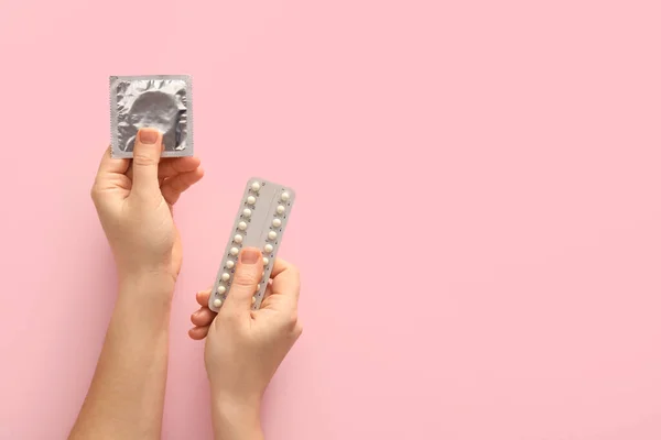 Vrouwelijke Handen Met Verpakt Condoom Anticonceptiepillen Kleur Achtergrond Close — Stockfoto