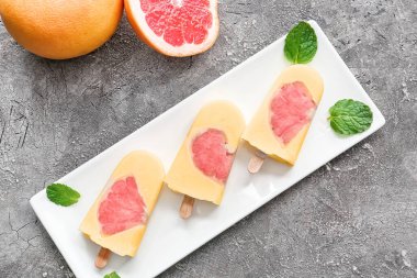 Arkaplanda lezzetli turunçgil dondurmalı tabak.