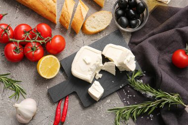 Beyaz peynirli tahta ve gri arka planda ürünler