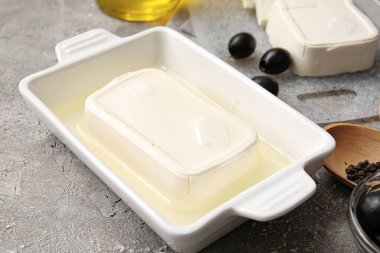 Gri arka planda beyaz peynirli fırın tabağı.