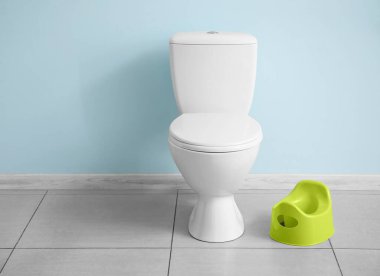 Klozet ve klozet döşemede, renkli duvarın yanında.