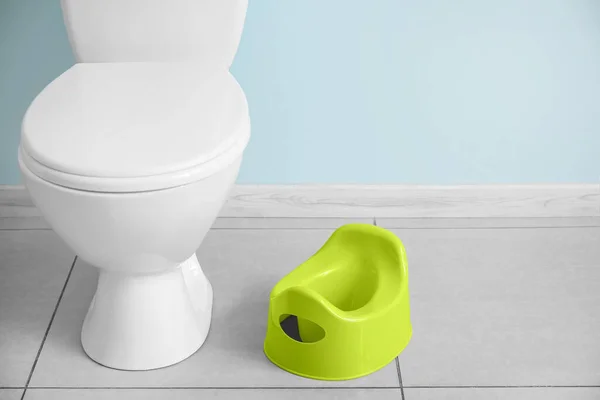 Töpfchen Und Toilettenschüssel Auf Grauem Fliesenboden Nahe Der Wand — Stockfoto