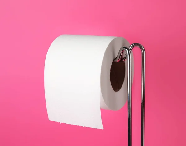 Holder with toilet paper roll on color background, closeup