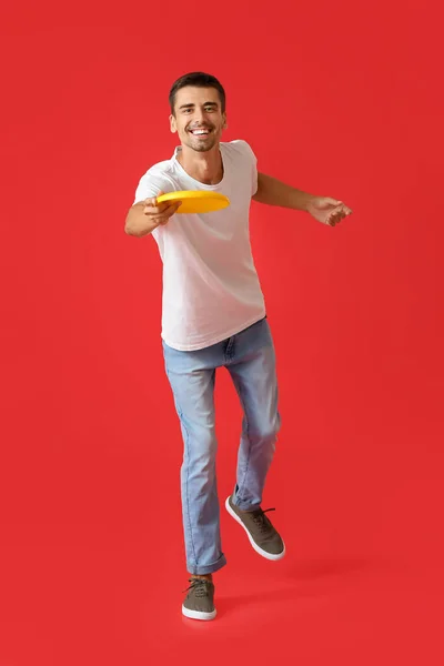 Bonito Jovem Jogando Frisbee Fundo Vermelho — Fotografia de Stock