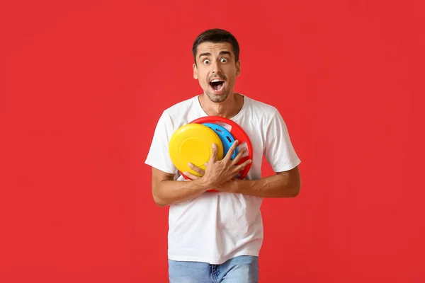 Překvapený Mladý Muž Frisbee Červeném Pozadí — Stock fotografie