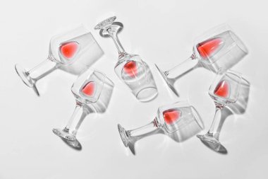 Açık arkaplanda kırmızı şarap artığı olan bardakların şık kompozisyonu