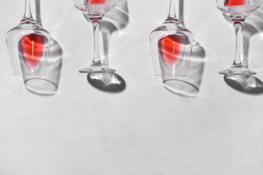 Açık arkaplanda kırmızı şarap artığı olan bardakların şık kompozisyonu