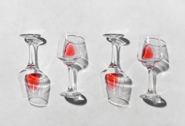 Açık arkaplanda kırmızı şarap artığı olan bardakların şık kompozisyonu