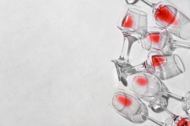 Açık arkaplanda bitmemiş kırmızı şarap kadehleri