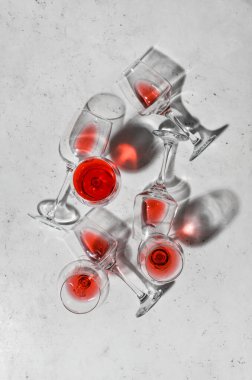 Açık arkaplanda bitmemiş kırmızı şarap kadehleri