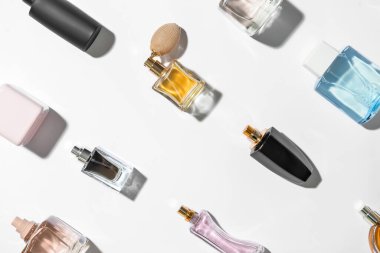 Beyaz arka planda farklı parfüm şişeleri olan kompozisyon