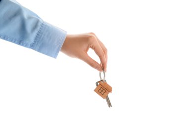 Beyaz arka planda ev şekilli anahtarlığı olan bir emlakçı.