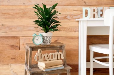 Odanın şık iç kısımlarında ahşap duvarın yanındaki merdivende alarm ve dekor.