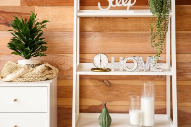 Şık bir odanın içindeki rafta dekoru olan altın alarm.