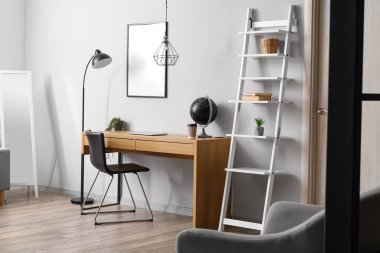 Işık duvarının yanında modern ahşap masa olan oda.